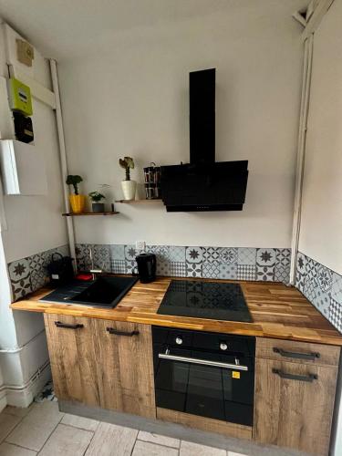 - une cuisine avec un comptoir en bois et une cuisinière dans l'établissement Apparemment chaleureux hyper centre Nancy, à Nancy