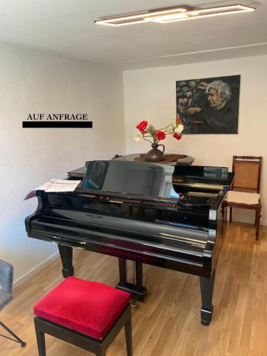 a piano in a living room with a red stool at Ferienhaus Schiefertraum in Fell
