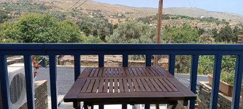 a wooden bench sitting on top of a balcony at Andros Guesthouses in Andros