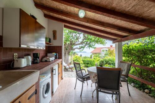 a kitchen with a table and chairs and a patio at Apartments Petrali in Mlini
