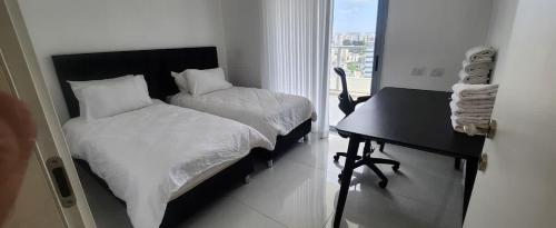 a bedroom with a bed and a desk and a window at The spectacular tallest penthouse in the city 4-BR in Qiryat Ata