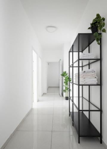 a hallway with white walls and a black shelf at The spectacular tallest penthouse in the city 4-BR in Qiryat Ata