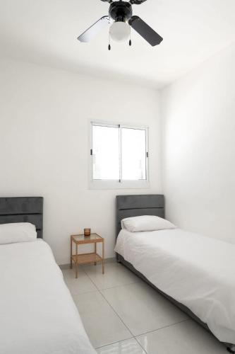 a bedroom with two beds and a ceiling fan at The spectacular tallest penthouse in the city 4-BR in Qiryat Ata