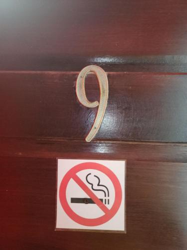 a no smoking sign on a wooden door with a handle at EL REY Hotel & Restaurant in Belmopan