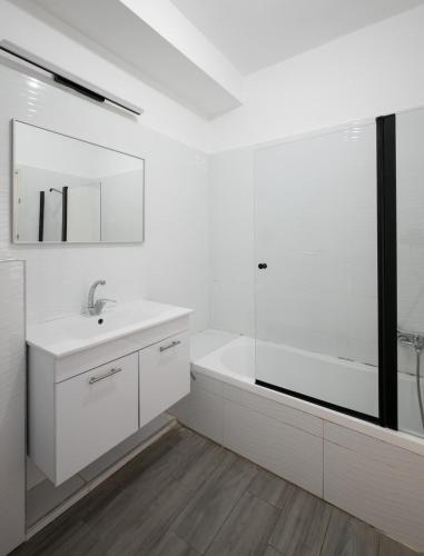 a white bathroom with a sink and a bath tub at Wonderful 4-BR APT in the center in Qiryat Ata