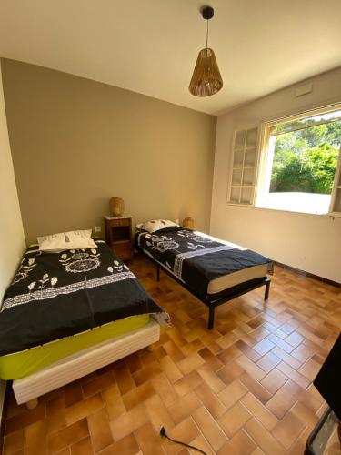 une chambre avec un lit et un parquet dans l'établissement Les Mourguettes, à Carpentras