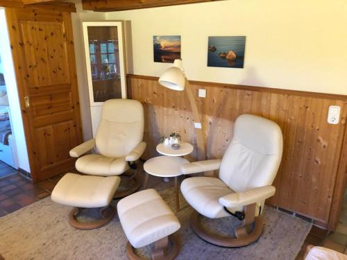 a waiting room with two chairs and a lamp at Die 5 Ferienwohnungen der Familie Weber in Fehmarn