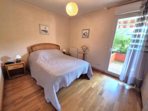 une chambre avec un lit et une grande fenêtre dans l'établissement Résidence Le Clos St Louis - Bel appartement au calme tout confort ! MAE-6424, à Aix-les-Bains