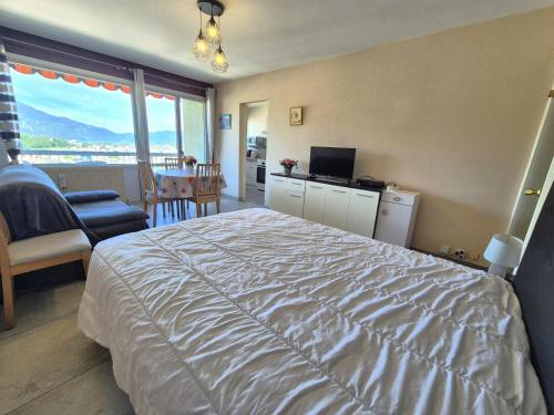 une chambre avec un grand lit avec une grande fenêtre dans l'établissement Résidence Le Cheverny - Agréable logement proche verdure, très belle vue dégagée ! MAE-7654, à Aix-les-Bains