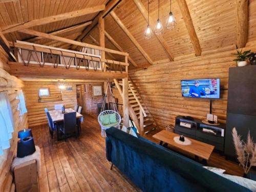 a living room of a log cabin with a couch and a tv at Inn Green, kuća 3 zvjezdice in Koprivnica