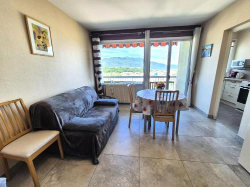 un salon avec un canapé, une table et des chaises dans l'établissement Résidence Le Cheverny - Agréable logement proche verdure, très belle vue dégagée ! MAE-7654, à Aix-les-Bains