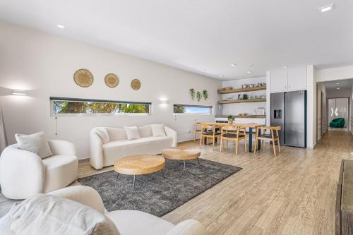 a living room with white furniture and a table at Boutique Hotel Bougainvillea in Kralendijk
