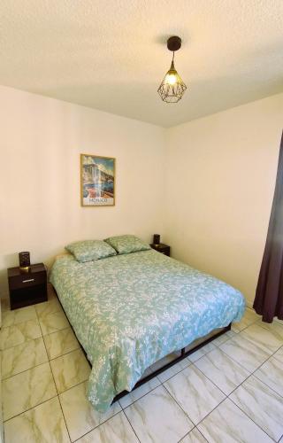 une chambre avec un lit et deux tables de nuit dans l'établissement Appartement Vasco - Esterel Experience, à Saint-Raphaël