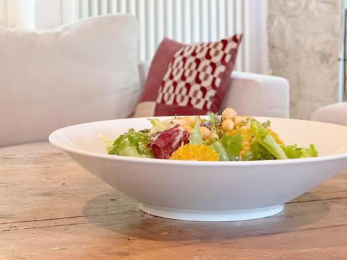 a salad in a white bowl on a wooden table at LeCannelleAgriBenessere in Belloca