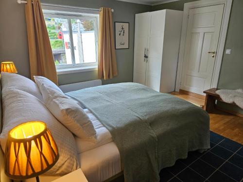 a bedroom with a bed with a lamp and a window at Sigurd's Loft in Vossevangen