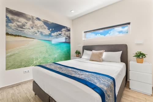 a bedroom with a bed and a painting of a beach at Boutique Hotel Bougainvillea in Kralendijk