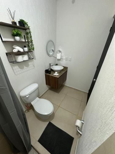 a bathroom with a white toilet and a sink at Departamento Orion 3 rooms planta baja en Cancun by EITA in Cancún