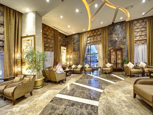 a lobby with couches and chairs in a building at Elaf Kinda Hotel in Makkah