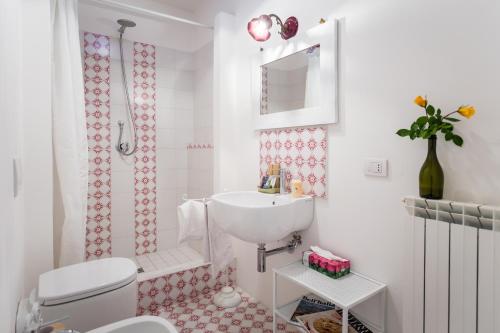 a white bathroom with a sink and a toilet at Podere Orto Wine Country House in Trevinano