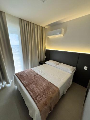 a bedroom with a large bed with a window at Apartamento Edifício Vista Mare in Torres