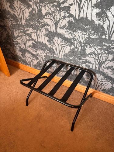 a metal bench sitting in front of a wall at Luxury Home in Dublin WiFi TV B&B Close to City Centre in Lucan