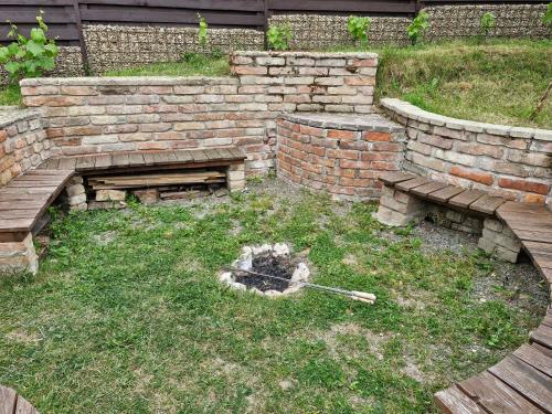a backyard with a brick wall and a fire pit at Dům Pálava in Perná