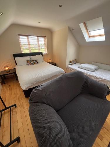 a bedroom with two beds and a couch in it at Luxury Home in Dublin WiFi TV B&B Close to City Centre in Lucan