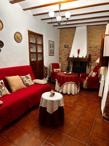 a living room with a red couch and a table at Rincón de Letur in Letur