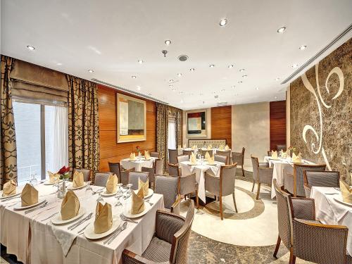 فندق إيلاف كندة في مكة المكرمة: مطعم فيه طاولات وكراسي في الغرفة
