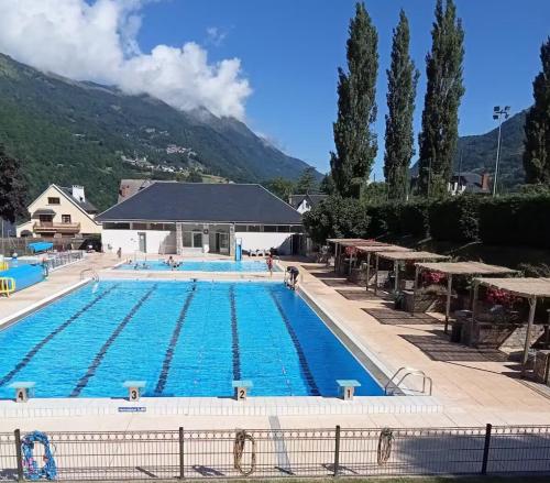a large swimming pool with a mountain in the background at Studio très proche du centre avec parking privé - fibre in Luz-Saint-Sauveur