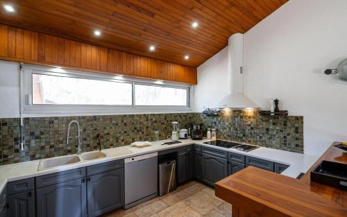 une cuisine avec un évier et une fenêtre dans l'établissement Villa Lou Lan, à Biscarrosse