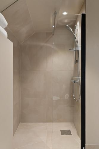 a shower with a glass door in a bathroom at Breitorget Apartments in Stavanger