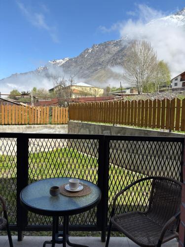 a table and chairs on a balcony with a view of a mountain at Devdaraki Apartments N 113 in Stepantsminda