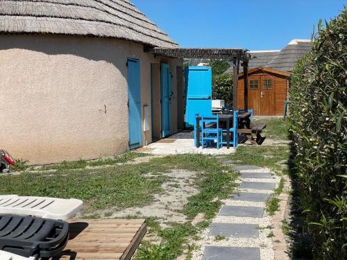 une maison avec une table et un banc dans une cour dans l'établissement MAS Chalet 6 7persClimPiscineJardin MER, au Barcarès