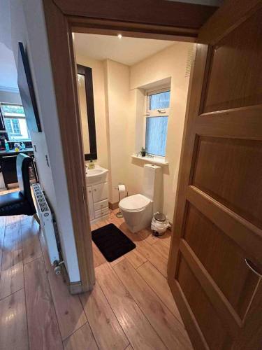 a bathroom with a toilet and a window and a door at Luxury Home in Dublin WiFi TV B&B Close to City Centre in Lucan