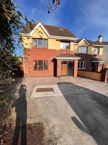 a person standing in front of a house at Luxury Home in Dublin WiFi TV B&B Close to City Centre in Lucan