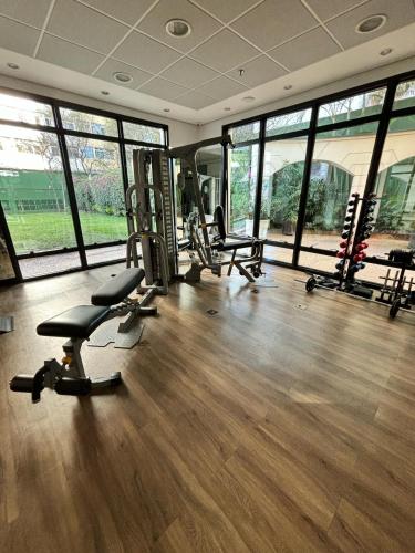 a gym with treadmills and chairs in a room with windows at Hotel Pamplona Jardins Univer com garagem 2402 in Sao Paulo