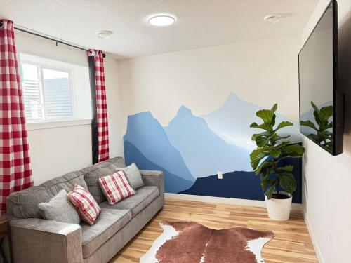 a living room with a couch and a mountain mural at Rustic Rocky Retreat in Calgary