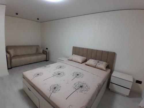 Un dormitorio con una cama y un sofá. en Люкс апартаменты -Центр, en Mykolaiv