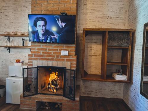 a fireplace with a tv on a brick wall at Refugio Victoria in Monte Verde