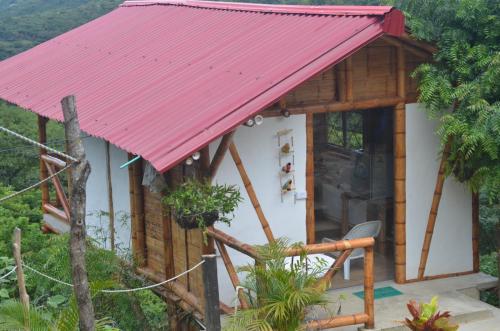 a small house with a red roof at El Eden Glamping cabañas Girardot in Girardot