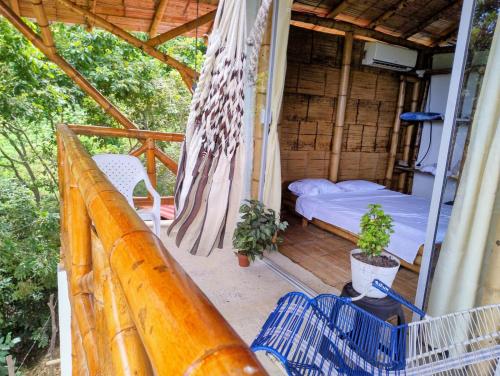 a room with a bed and a hammock on a porch at El Eden Glamping cabañas Girardot in Girardot