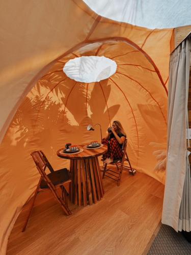 a woman sitting at a table in a tent at Arenal Nest in San Francisco