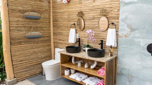 a bathroom with a wooden wall with two sinks and mirrors at Arenal Nest in San Francisco