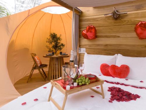 a bed in a tent with a tray of fruit on a table at Arenal Nest in San Francisco