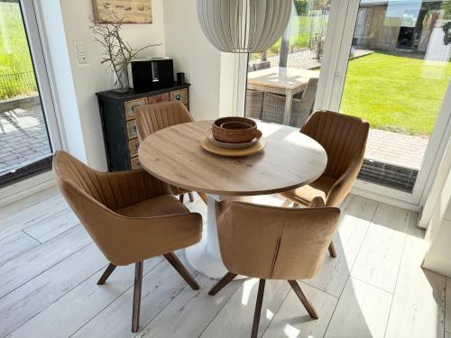 a wooden table and chairs in a room at Die 5 Ferienwohnungen der Familie Weber in Fehmarn