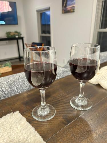 two glasses of red wine sitting on a wooden table at Clayton Dahlia Retreat in Clayton