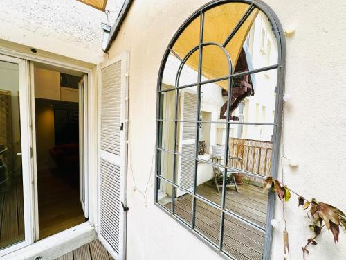 ein Bogenfenster an der Seite eines Hauses in der Unterkunft LE LAVADIÈRE - Joli duplex avec terrasse in Sèvres