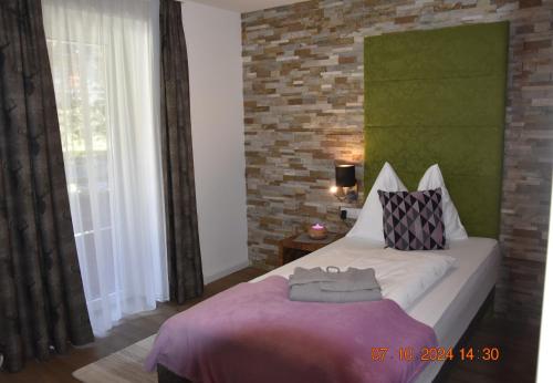 a bedroom with a bed and a brick wall at Landhotel Anna in Sankt Martin am Tennengebirge