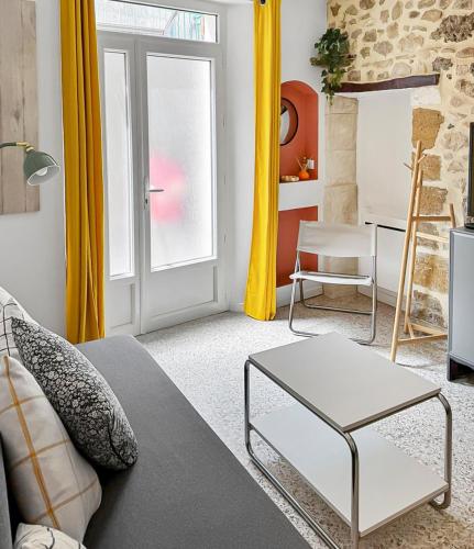 un salon avec un canapé et une table dans l'établissement Appartement Cosy au calme, à Noves